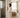 Woman in a soft robe stands between a bright bathroom and calm bedroom, showing the choice between a drying bathrobe and a warm dressing gown.