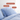 Light blue organic cotton sateen pillows and duvet on a bed with labels for hypoallergenic, temperature-regulating, and natural properties