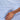 Close-up of a hand resting on light blue organic cotton sateen fabric