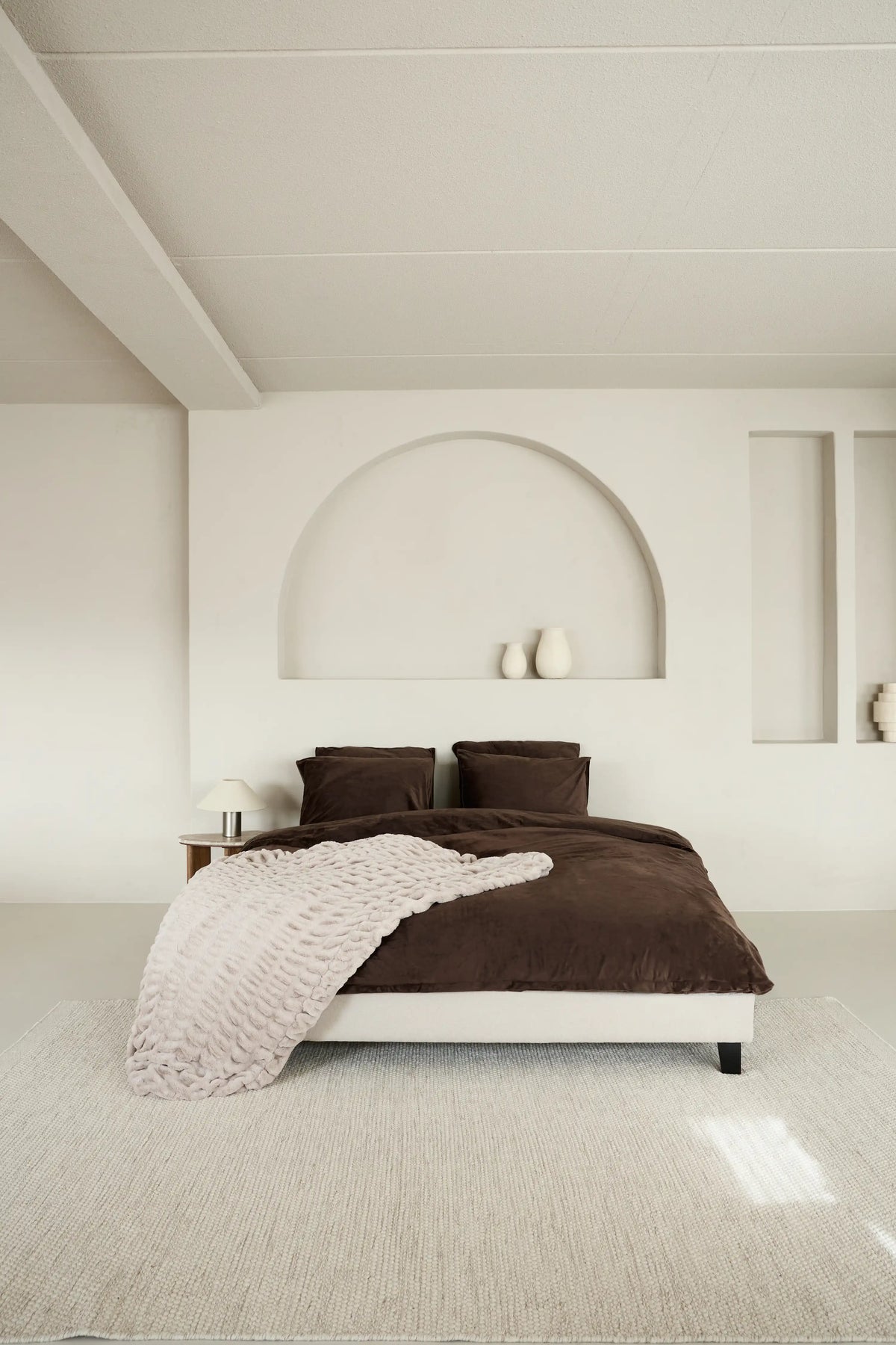 SJUMO Silky Smooth dekbedovertrekset in Dark Brown met de SJUMO plaid in Sand Cloud in een minimalistische slaapkamer